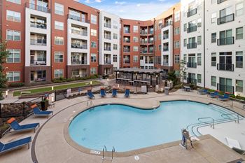 a swimming pool with an apartment building in the background